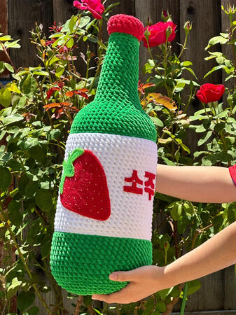 2 foot tall crocheted soju bottle with felt strawberry embellishment