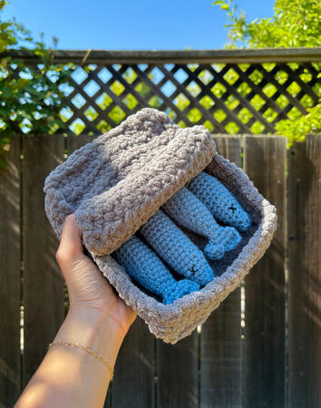 Four removable blue sardines in a gray plush tin